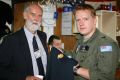 During celebrations of the 70th Anniversary of 10 and 11 Squadron held at Royal Australian Air Force Base Edinburgh, Sergeant Bueller hands retired 10 and 11 Squadron member, Garth Morgan a
10 Squadron T-shirt.